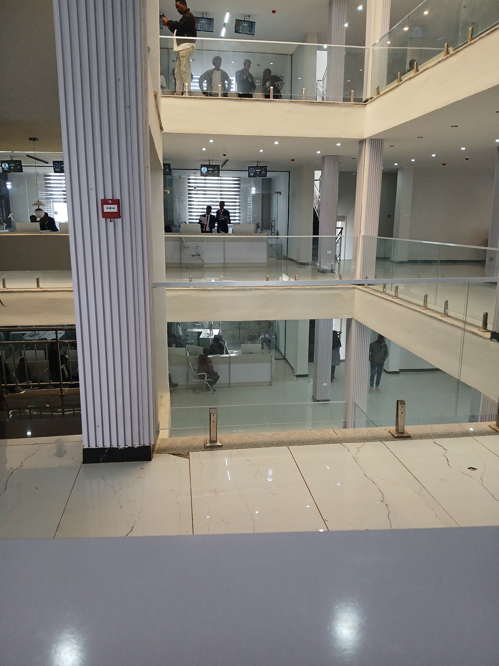 The multi-storey atrium at Burayu Mesob, with glass railings, service offices and a tall central column